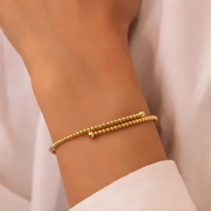 Bracelet perles en or lisses sur poignet